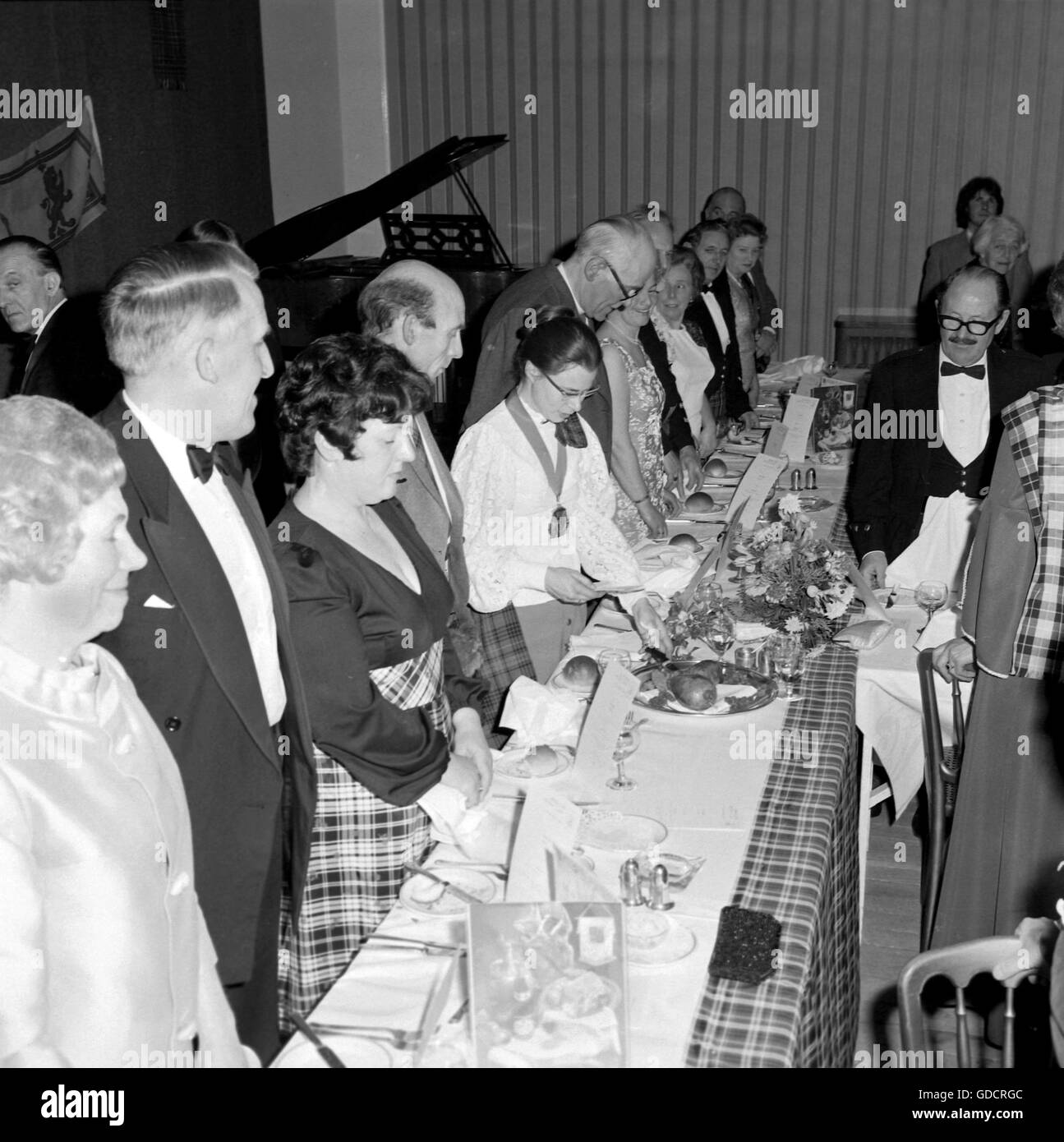Caledonian società brucia la notte c1968. Una serata solenne celebrazione della vita e la poesia del poeta Robert Burns . La serata comprendeva abito tradizionale con uomini che indossano kilts, un suonatore di cornamusa scozzese con cornamusa, una formale diffusione di cibo tra cui tradizionale haggis e abbondanza di bere! Ci sono stati anche alcuni anni sessanta mode e acconciature del tempo. Fotografia di Tony Henshaw Foto Stock