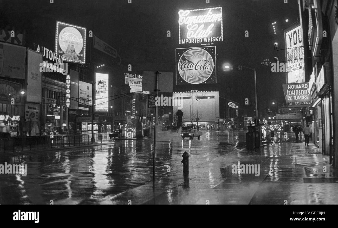 Serata piovosa a Time Square con riflessioni in carreggiata Foto Stock