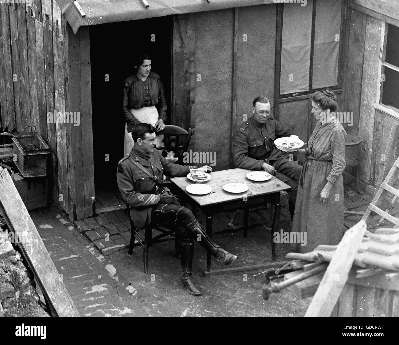 La prima guerra mondiale c1918 Un ufficiale con un falso braccio ed un privato di essere servito il pranzo in una caffetteria di fortuna. Nota il pane impilati e umili dintorni. Le scene alla fine della prima guerra mondiale 1 c1918/1919 distruzioni a San Quintino. a partire da un insieme di una lastra di vetro le foto scattate da un ONU-denominato esercito britannico medico Foto di Tony Henshaw Foto di Tony Henshaw scansionati direttamente da un 5x4' negativo originale © Mondo copyright. Foto Stock