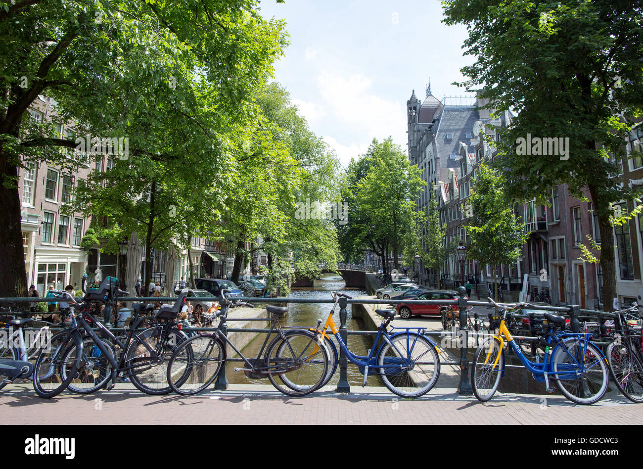 Biciclette su un ponte sul Canal Amsterdam Olanda Foto Stock