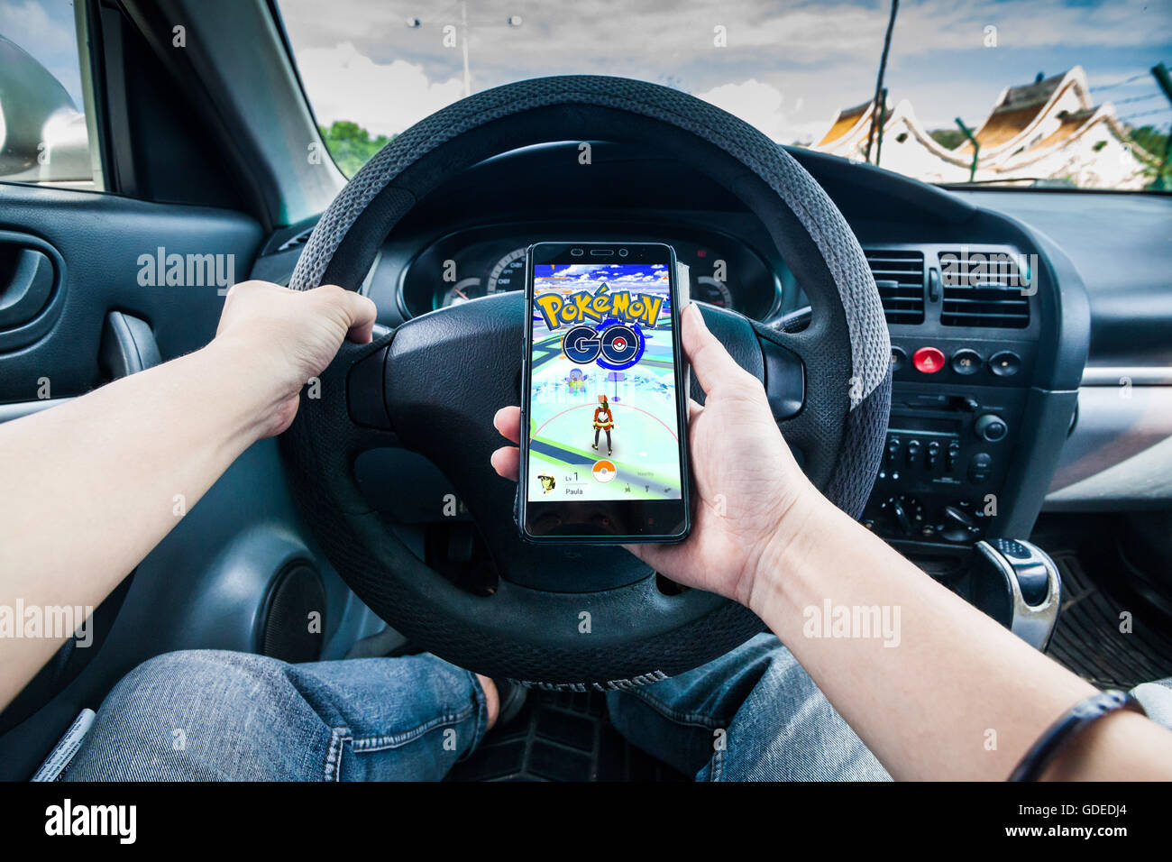 Pokemon Go gioco mentre la guida pericolosa Foto Stock