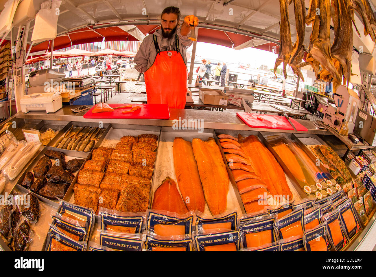 Fisherman tenendo un campione di salmone al suo pesce in stallo il famoso Bergen Mercato del Pesce di Bergen, Norvegia, Hordaland, Scandanavia Foto Stock