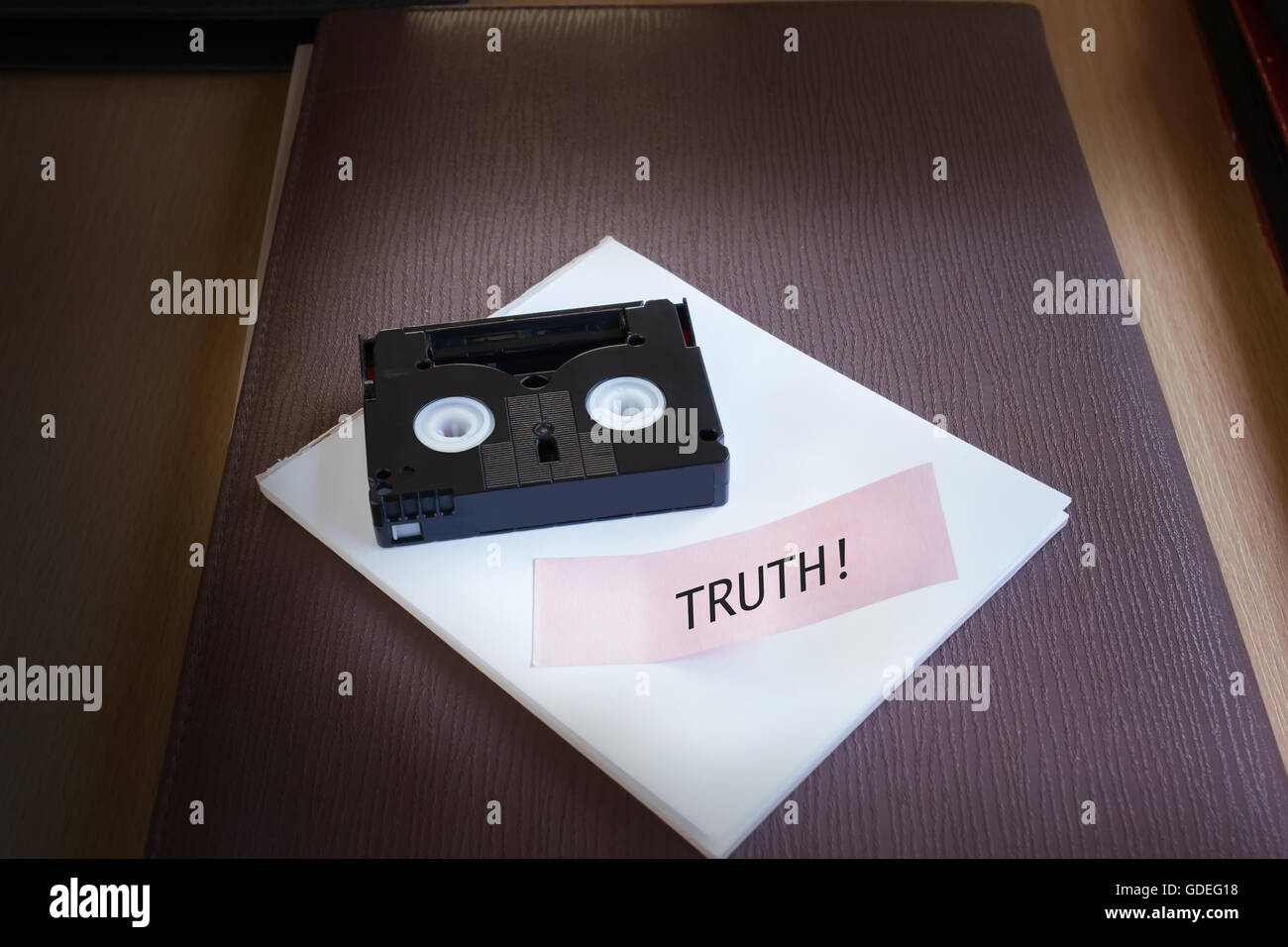 Cassetta Mini DV tape sulla nota di testo parola truthin luce fioca nackground camera con spazio di copia Foto Stock