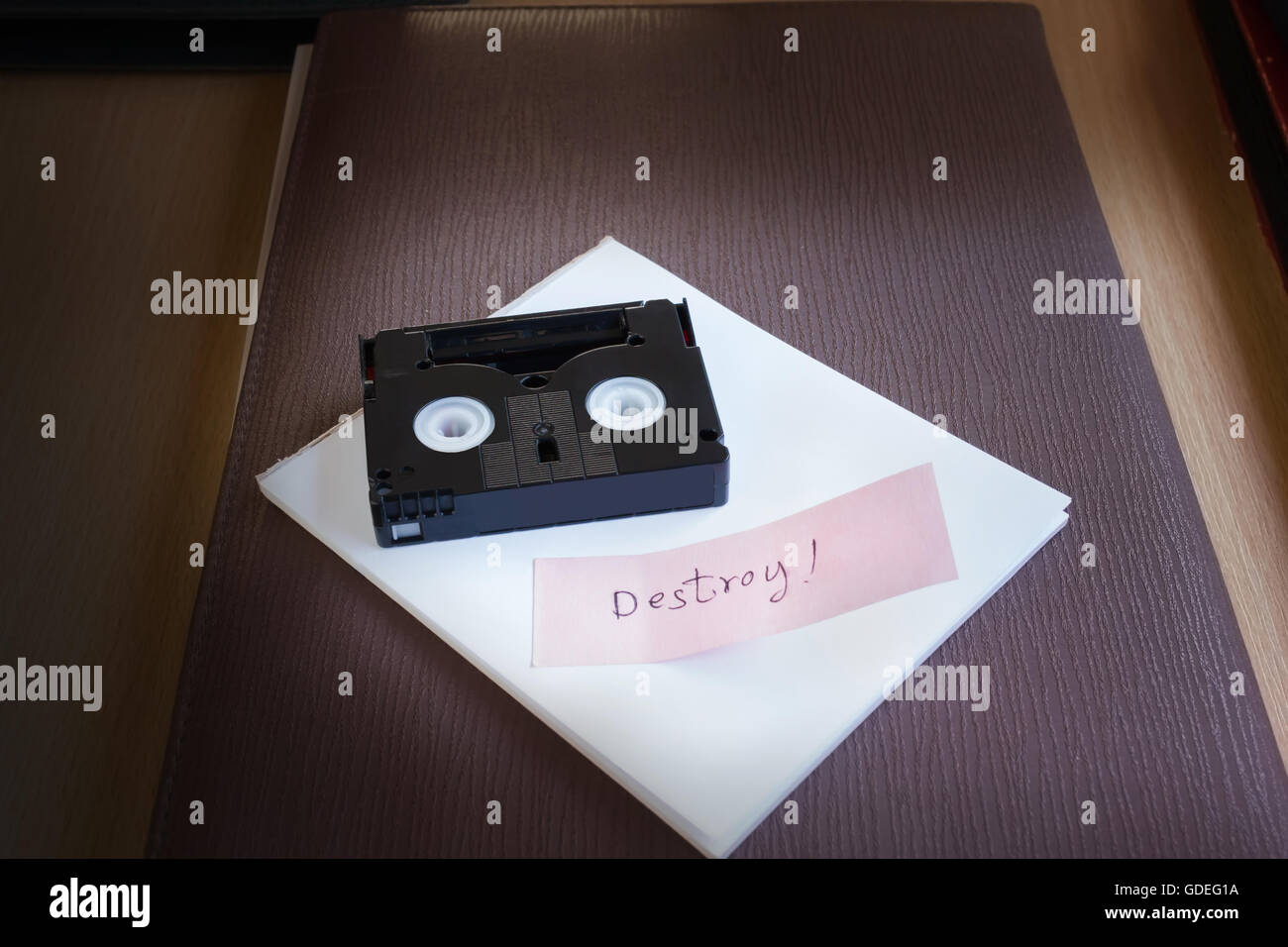 Cassetta Mini DV tape sulla nota di testo parola distruggere nella luce fioca nackground camera con spazio di copia Foto Stock