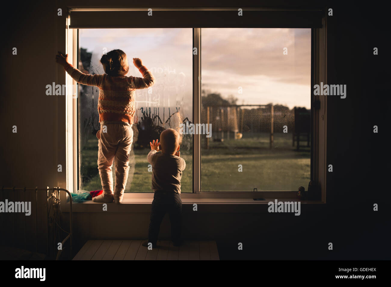 Un ragazzo e una ragazza disegno nella finestra al mattino la formazione di condensa Foto Stock