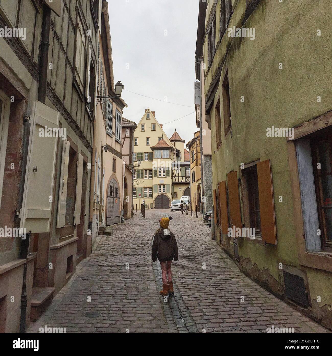 Ragazza camminare attraverso strade di Colmar, Alsazia Lorena, Francia Foto Stock