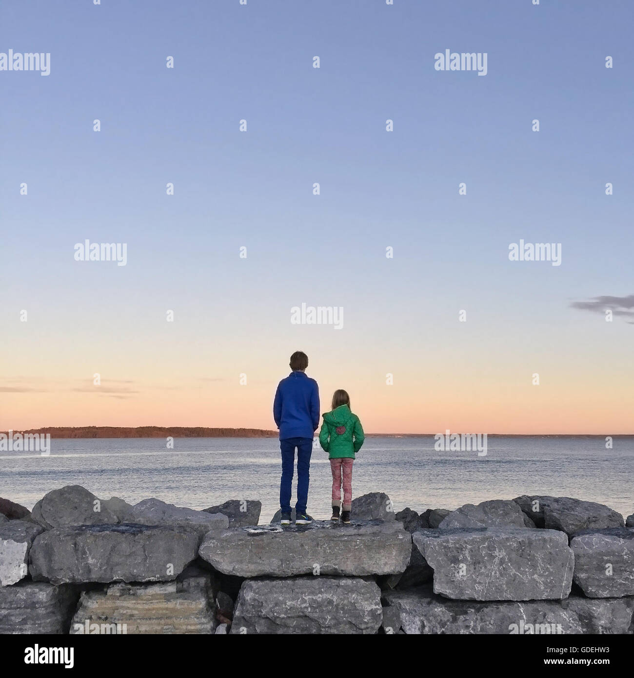 Un ragazzo e una ragazza in piedi sulle rocce dal mare, Asgardstrand, Norvegia Foto Stock