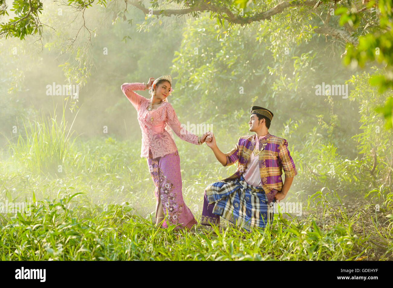 L uomo e la donna in abiti tradizionali Holding Hands, Asia Foto Stock