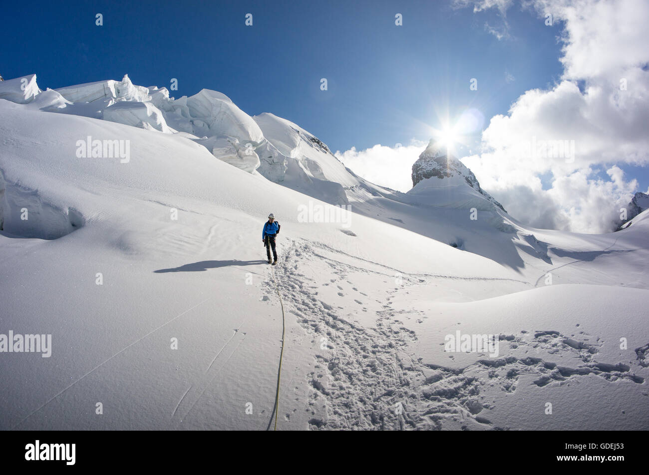 Uomo che cammina sul ghiacciaio delle Alpi svizzere, il Piz Bernina, Grigioni, Svizzera Foto Stock