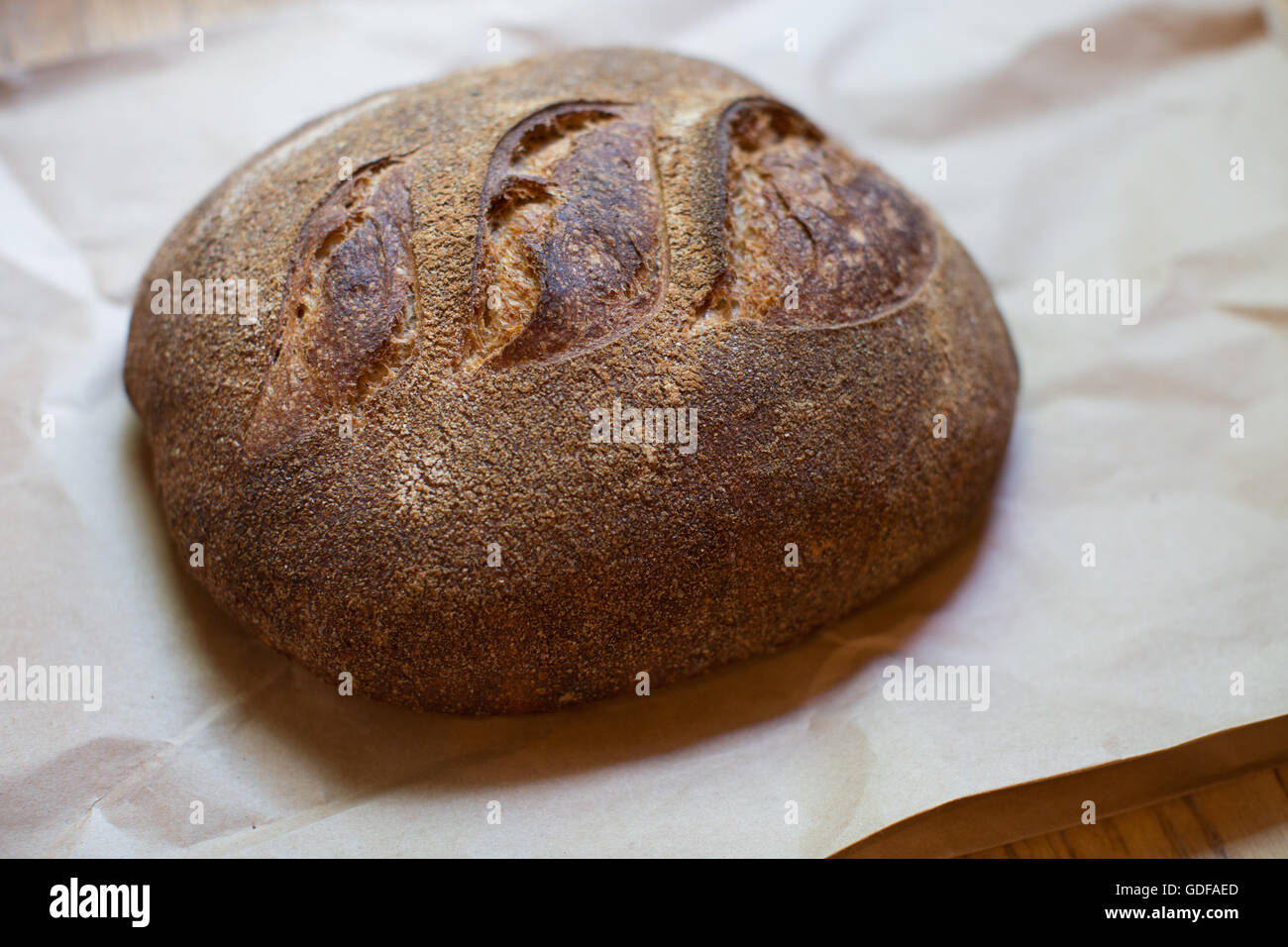 Pane appena sfornato a mano il pane biologico il raffreddamento in una pasticceria Foto Stock