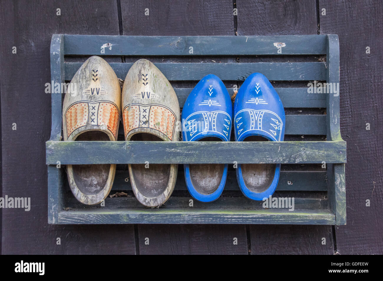 Due paia di scarpe di legno in un rack Foto Stock