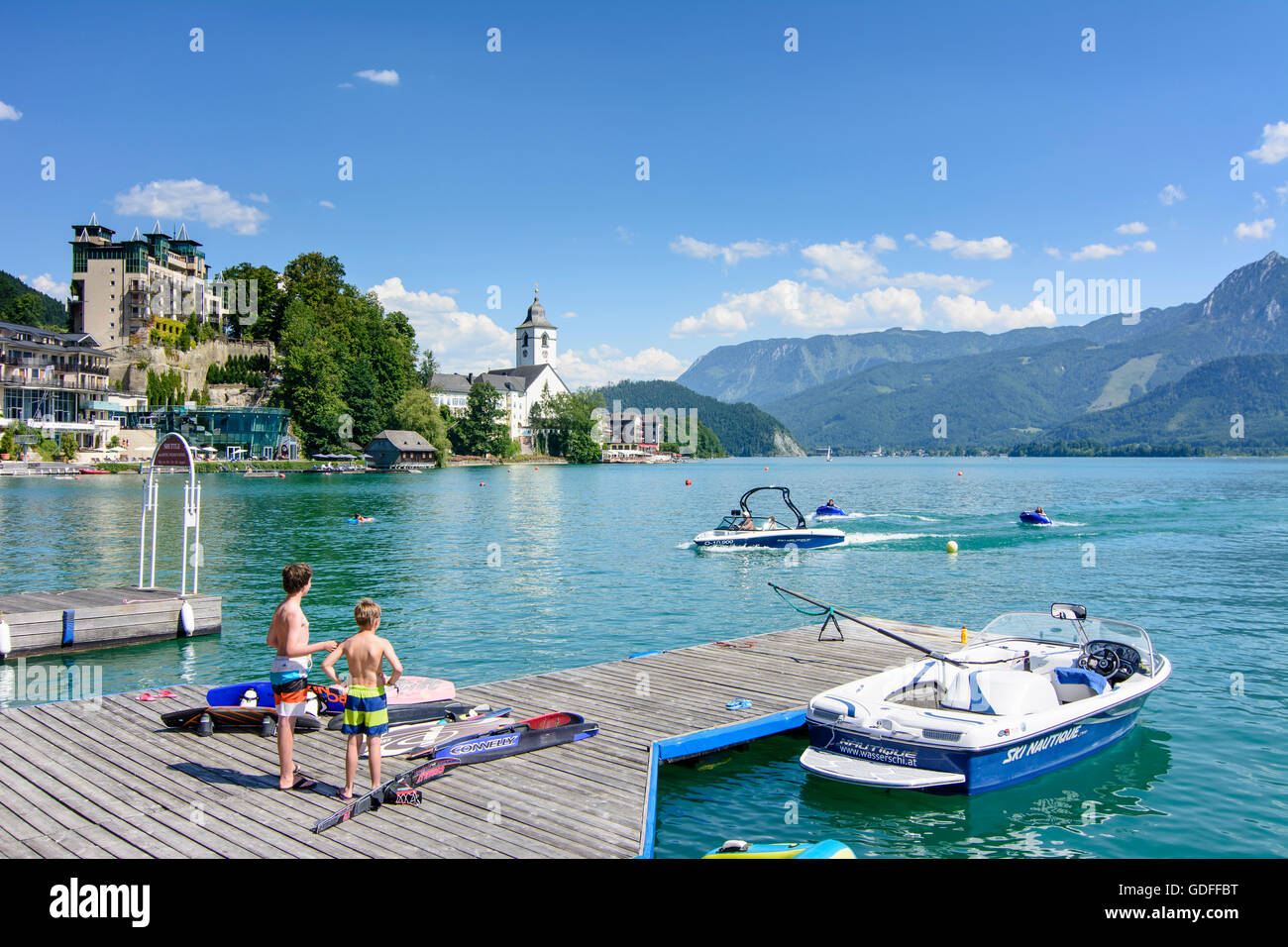 San Wolfgang: il lago Wolfgangsee e St. Wolfgang con pontile e imbarcazione a motore con 2 bambini nei tubi, Austria, Oberösterreich, fino Foto Stock
