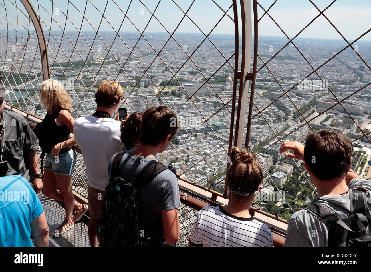 I turisti ammirando la vista verso Les Invalides sul livello superiore di calpestio della Torre Eiffel a Parigi, Francia. Foto Stock