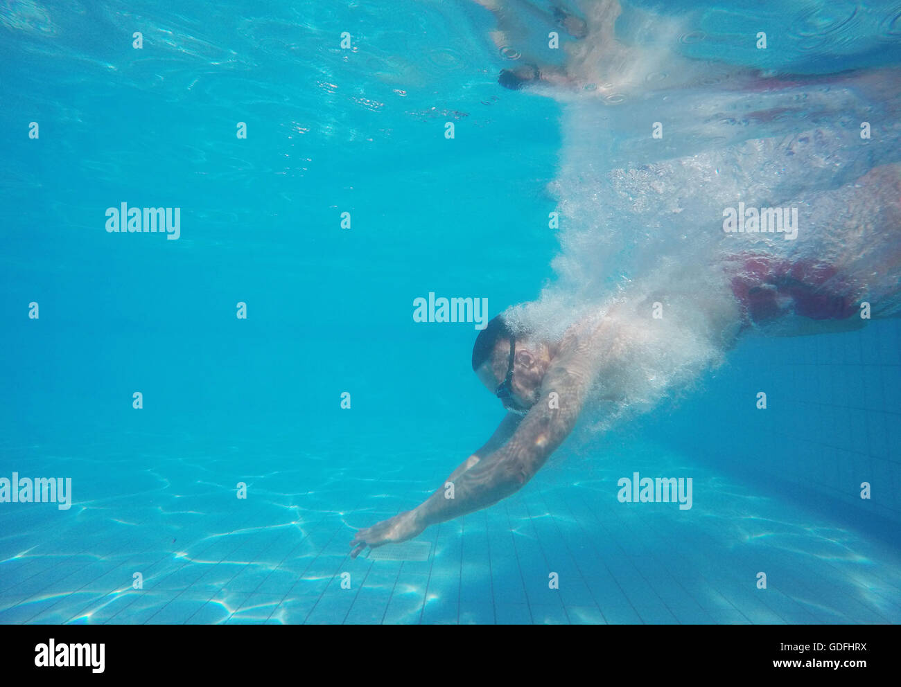 Barba Giovane Uomo con occhiali di immersioni in un pool Foto Stock