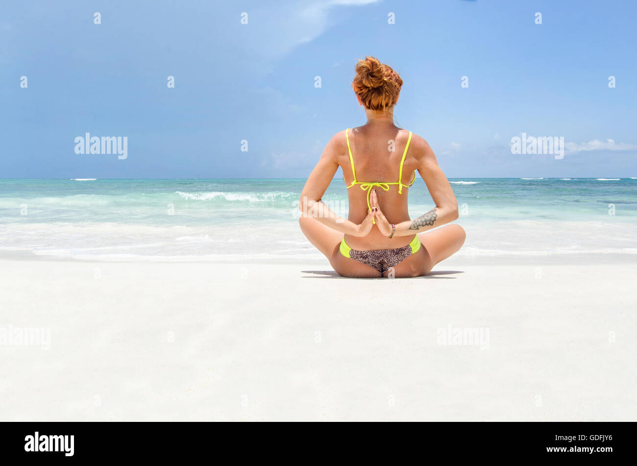 Giovane donna fare yoga in spiaggia Foto Stock