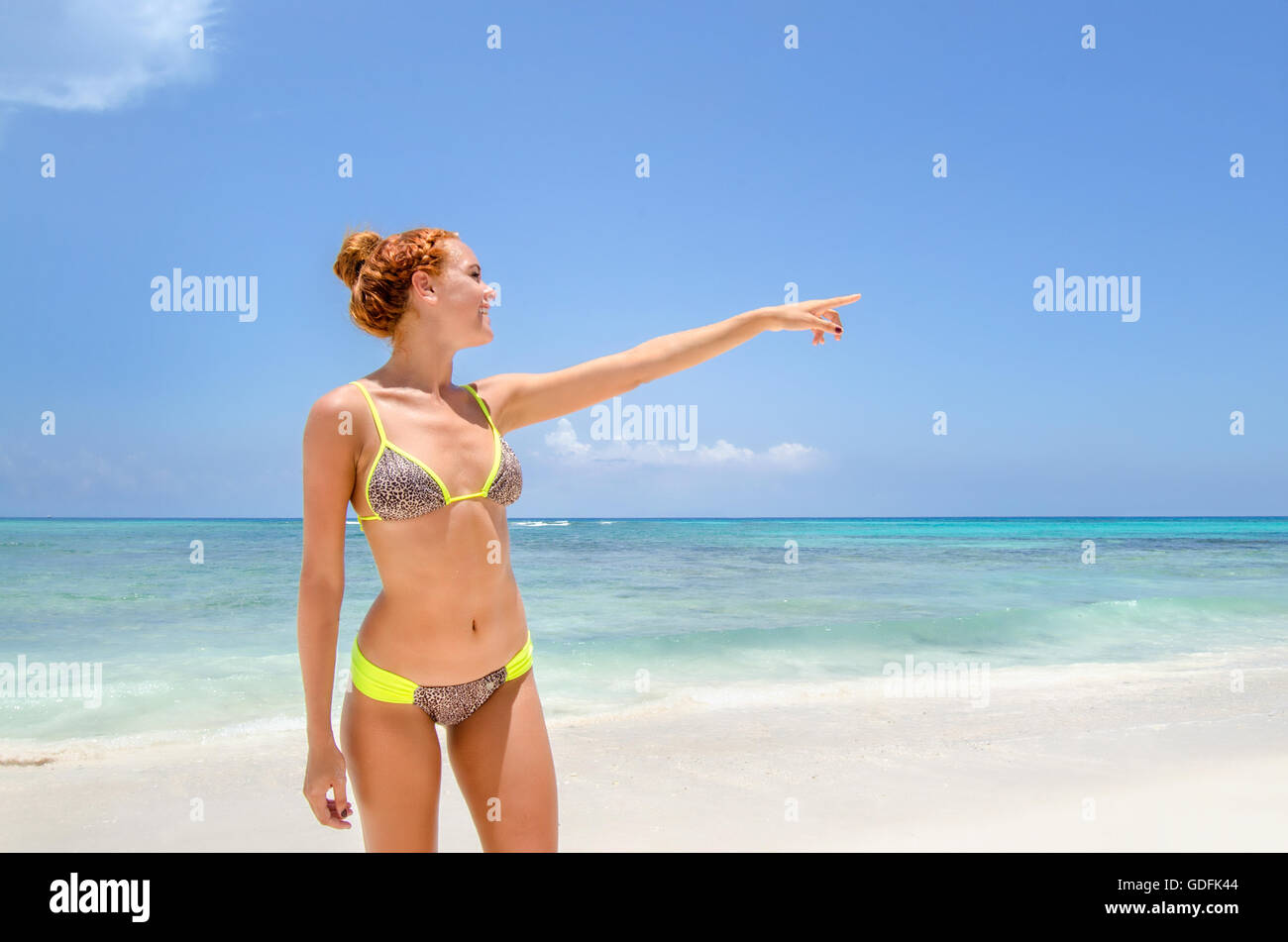 Piuttosto giovane donna puntando verso la spiaggia Foto Stock