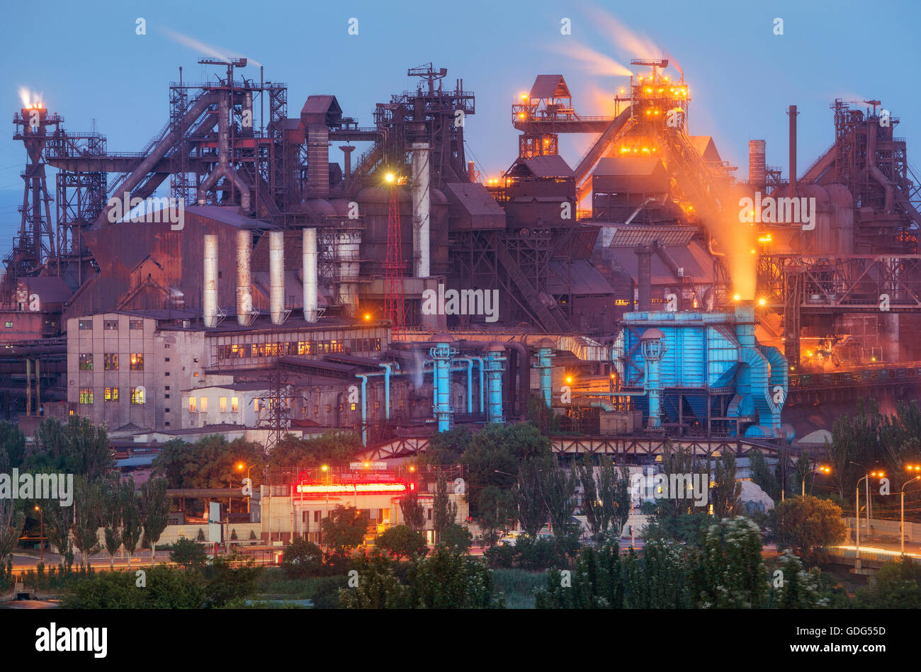 Stabilimento metallurgico di notte. Fabbrica di acciaio con fumaioli . Acciaierie e lavori di ferro. Industria pesante in Europa. Inquinamento atmosferico f Foto Stock