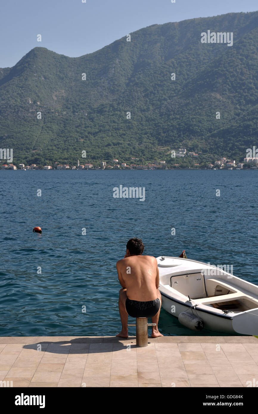 Uomo seduto in riva a Perast, Montenegro Foto Stock