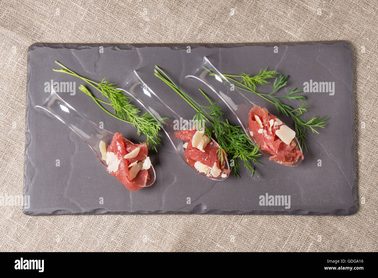 Antipasti di carne, Carpaccio e Parmigiano servito su un cucchiaio Foto Stock