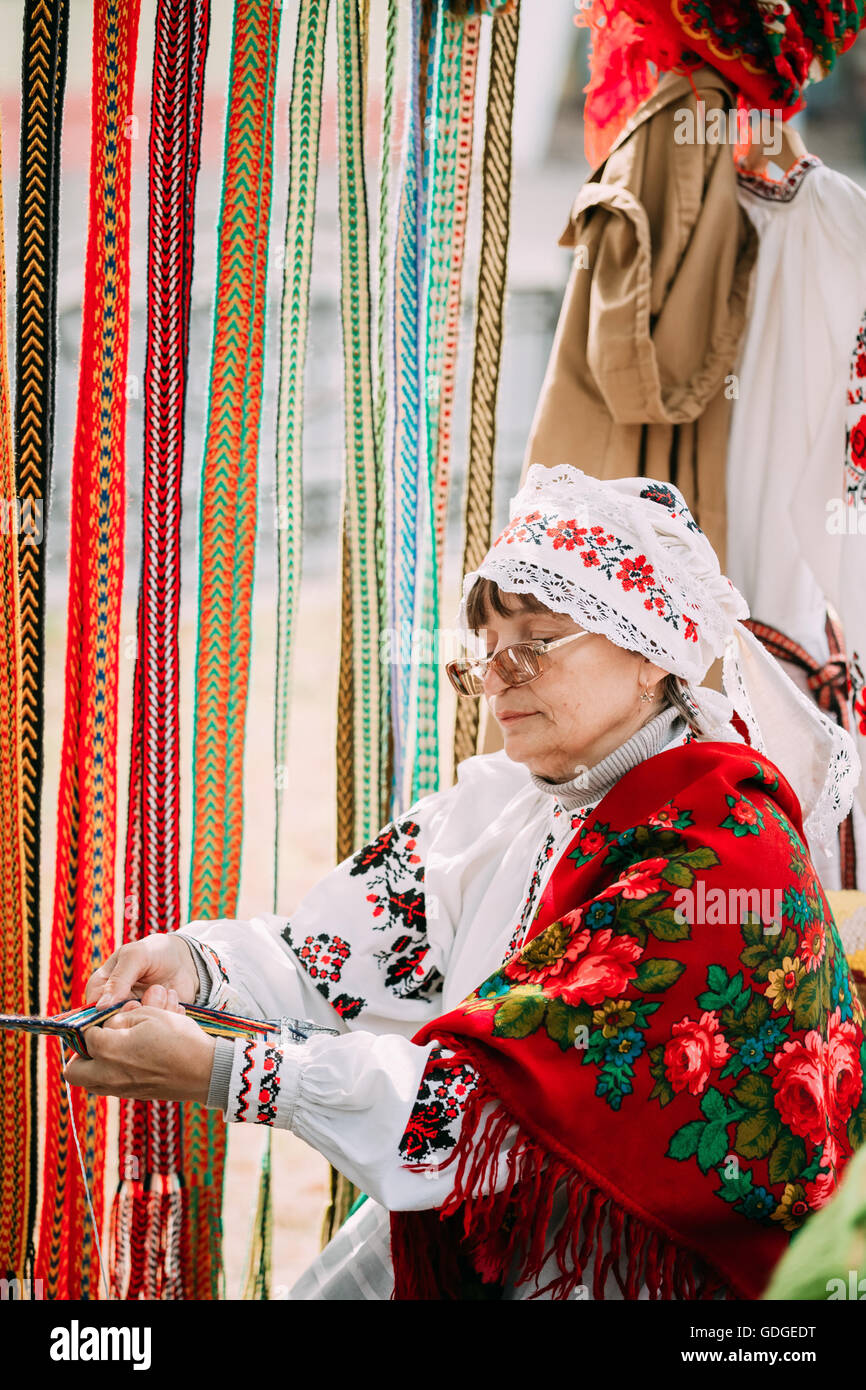 Gomel, Bielorussia - Settembre 12, 2015: Donna in nazionale bielorussa costume folk cinghia di tessitura Foto Stock