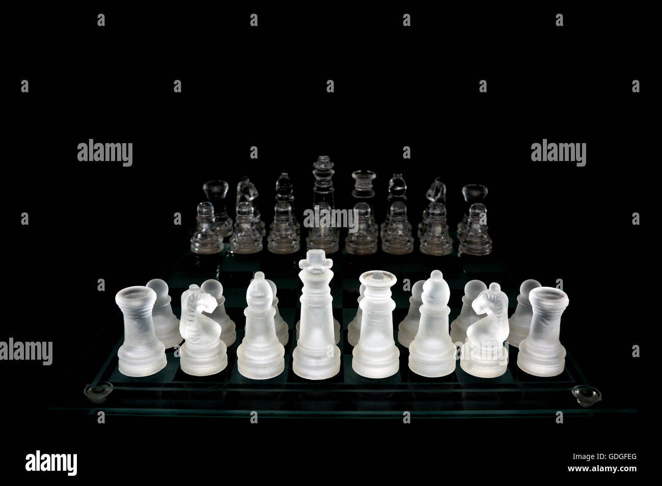 Scacchi di cristallo pezzi su una riga .su sfondo nero. Foto Stock