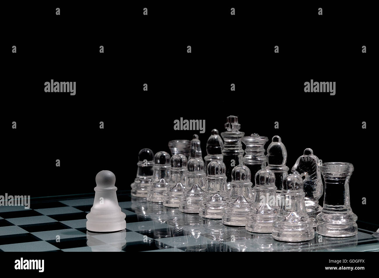 Scacchi di cristallo pezzi su una riga .su sfondo nero. Foto Stock