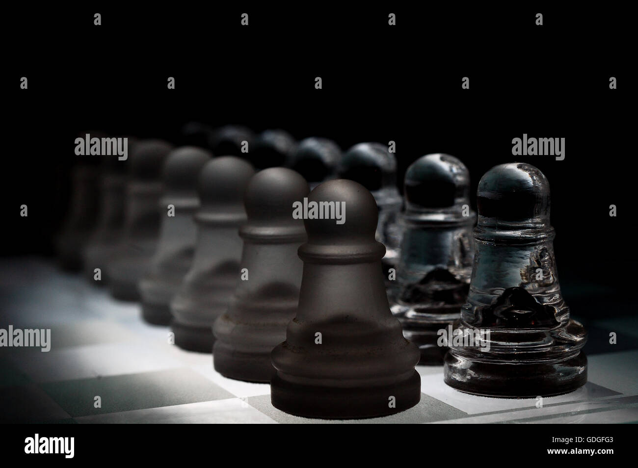Scacchi di cristallo pezzi su una riga .su sfondo nero. Foto Stock