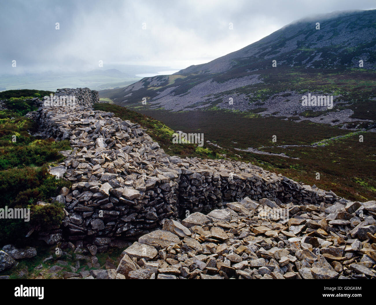 Visualizzare WSW del bastione interno & main (NW) ingresso di tre'r Ceiri hillfort, (città di giganti), Lleyn Peninsula, con picco centrale di Yr Eifl a R. Foto Stock