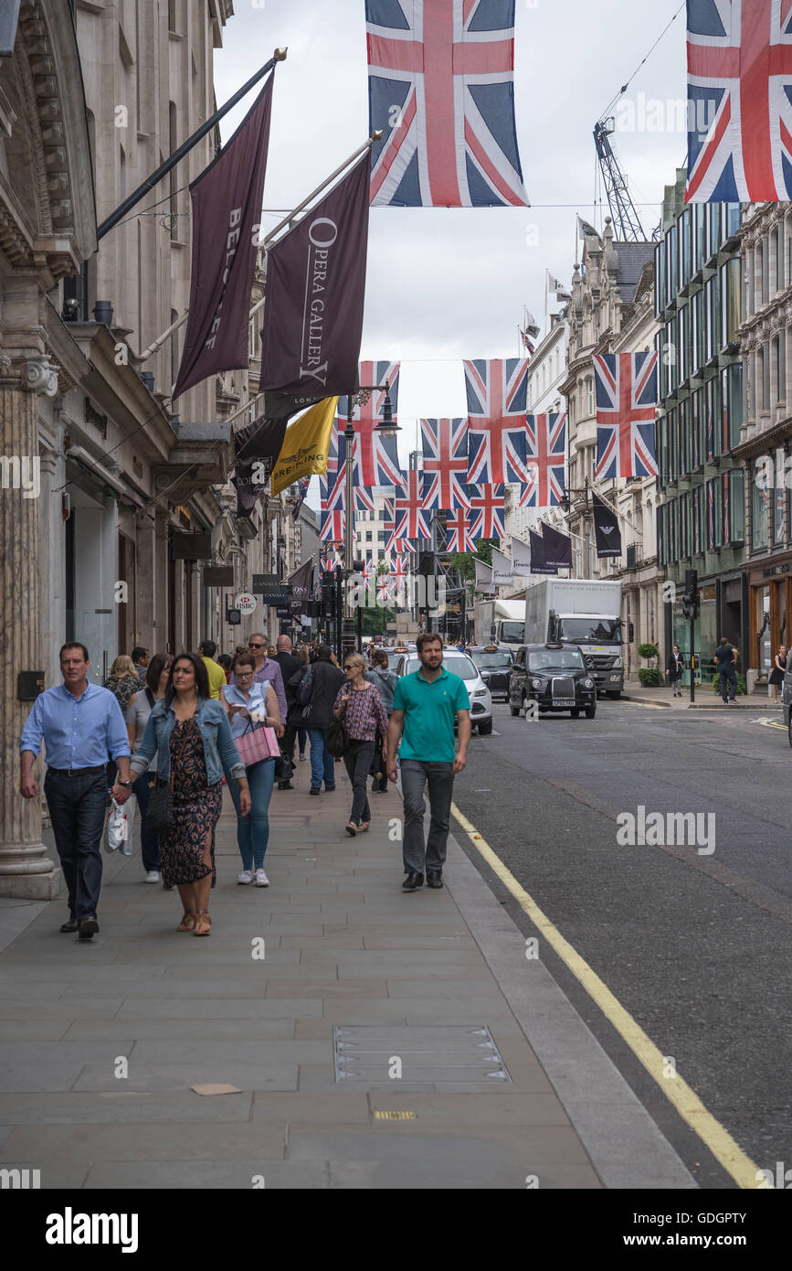 Scena di strada in Old Bond Street, Londra. La strada è decorata con union jack flag per celebrare il nostro queens novantesimo compleanno. Foto Stock