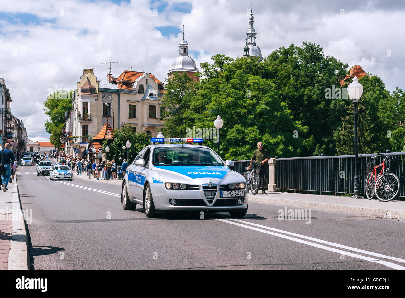 Polacco convoglio di polizia su un ponte con una vista sulle torri del centro storico in background. Foto Stock