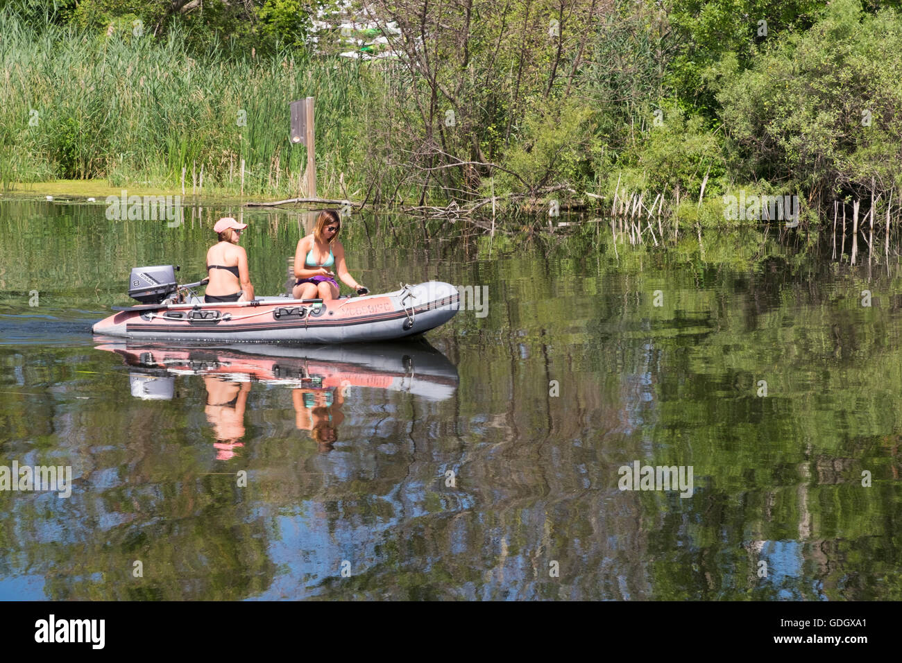 Due belle giovani donne in barca sul Fiume Bianco vicino a Whitehall, Michigan. Foto Stock