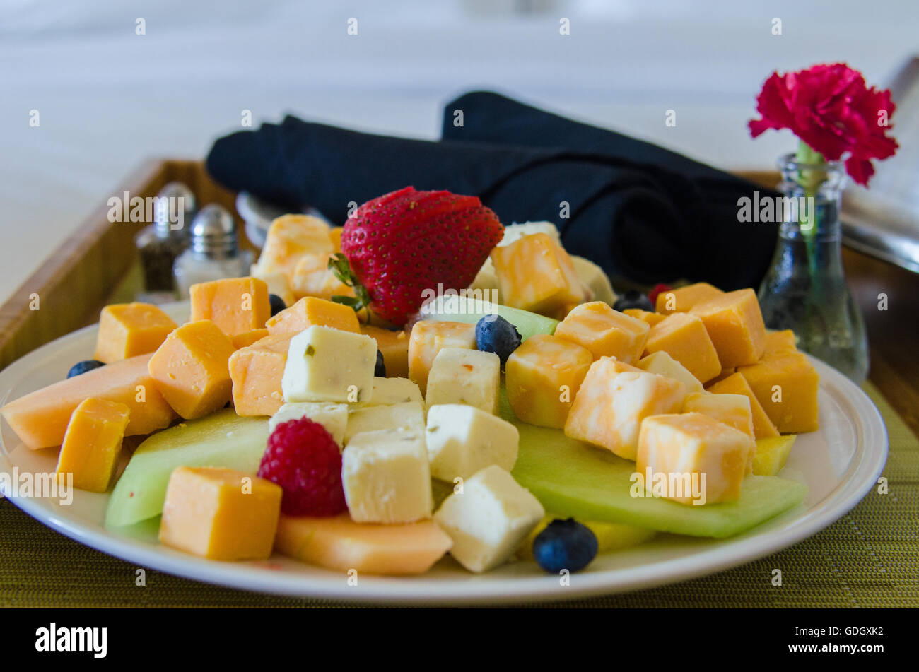 Servizio in camera Servizio vassoio con formaggio e frutta con vaso e fiore su hotel bed Foto Stock