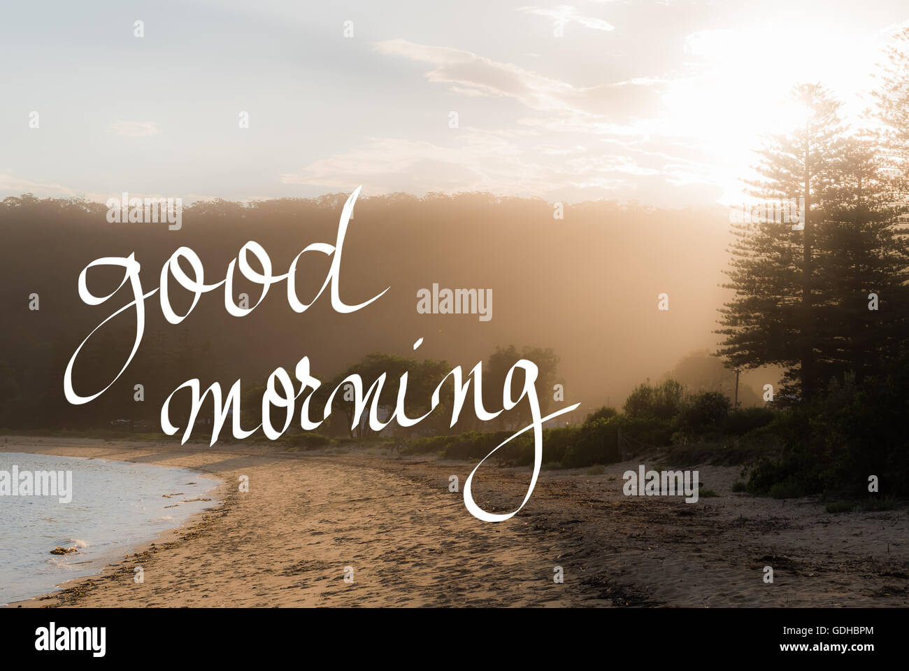 Buona mattina saluto. Manoscritta testo motivazionale su sunset calma spiaggia soleggiata con sfondo vintage filtro applicato Foto Stock