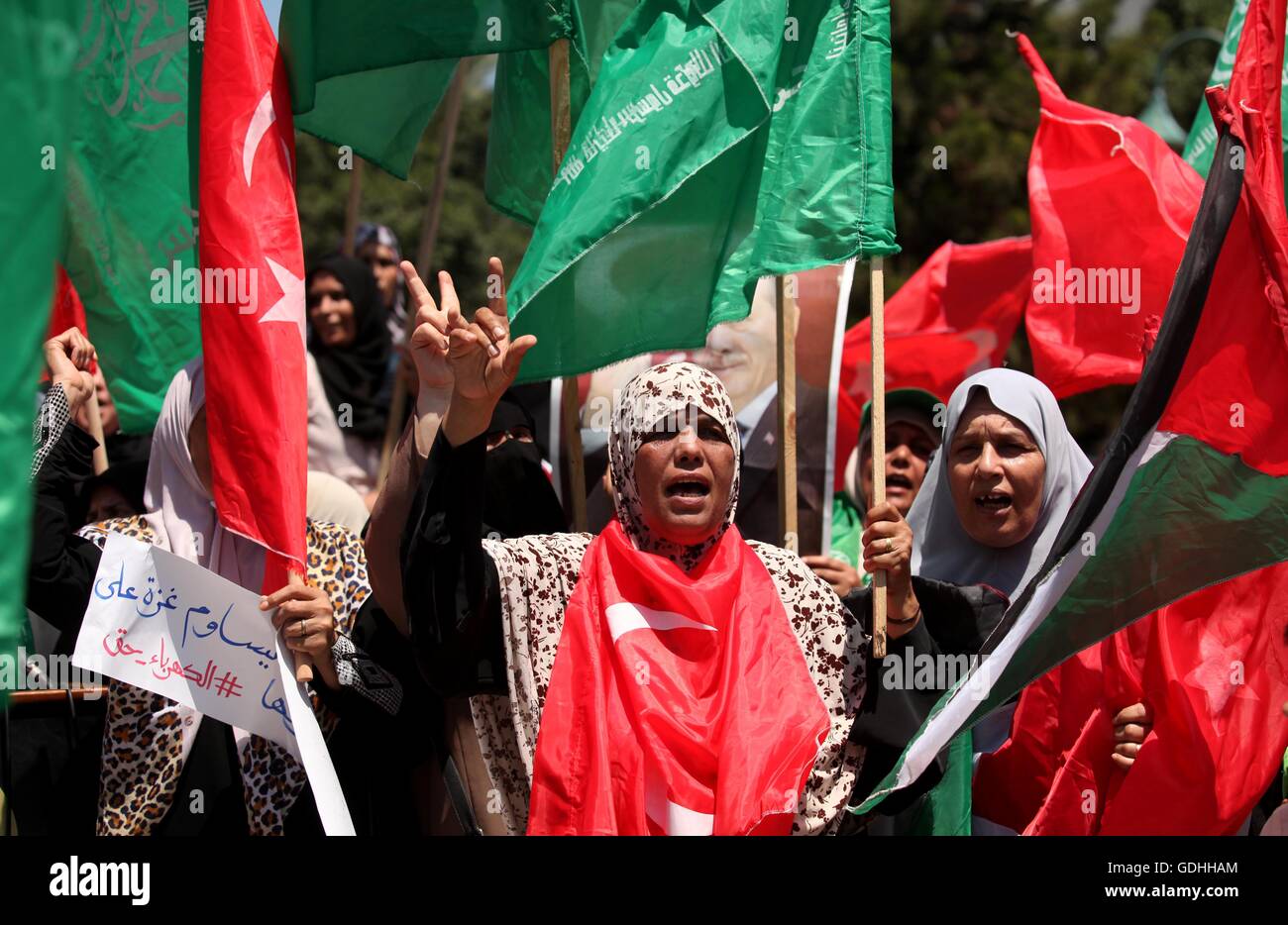 Khan Younis, Striscia di Gaza, Territori palestinesi. 17 Luglio, 2016. Sostenitori palestinese del movimento Hamas tenere i ritratti del Presidente turco Recep Tayyip Erdogan come essi gridare slogan contro i militari tentativo di colpo di stato in Turchia, nel corso di una manifestazione a Gaza City, il 17 luglio 2016. Le autorità turche hanno strappato nuovamente il controllo del paese il 16 luglio dopo la frantumazione di un colpo di stato militare perpetrato da soldati scontenti che cercano di conquistare il potere del presidente di Recep Tayyip Erdogan che ha sostenuto più di 250 vive © Ashraf Amra/immagini APA/ZUMA filo/Alamy Live News Foto Stock