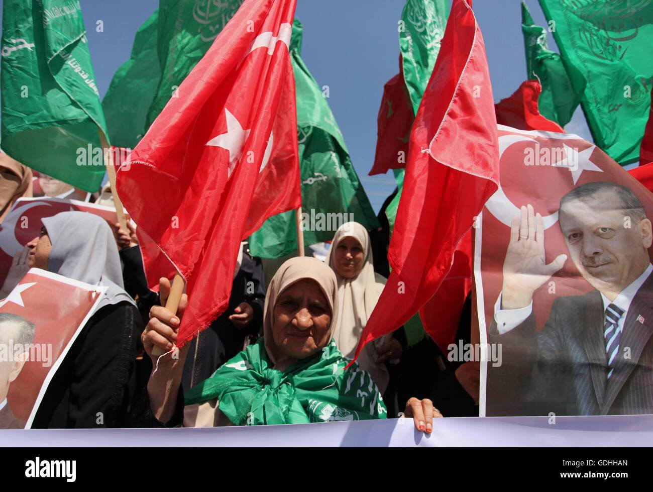 Khan Younis, Striscia di Gaza, Territori palestinesi. 17 Luglio, 2016. Sostenitori palestinese del movimento Hamas tenere i ritratti del Presidente turco Recep Tayyip Erdogan come essi gridare slogan contro i militari tentativo di colpo di stato in Turchia, nel corso di una manifestazione a Gaza City, il 17 luglio 2016. Le autorità turche hanno strappato nuovamente il controllo del paese il 16 luglio dopo la frantumazione di un colpo di stato militare perpetrato da soldati scontenti che cercano di conquistare il potere del presidente di Recep Tayyip Erdogan che ha sostenuto più di 250 vive © Ashraf Amra/immagini APA/ZUMA filo/Alamy Live News Foto Stock