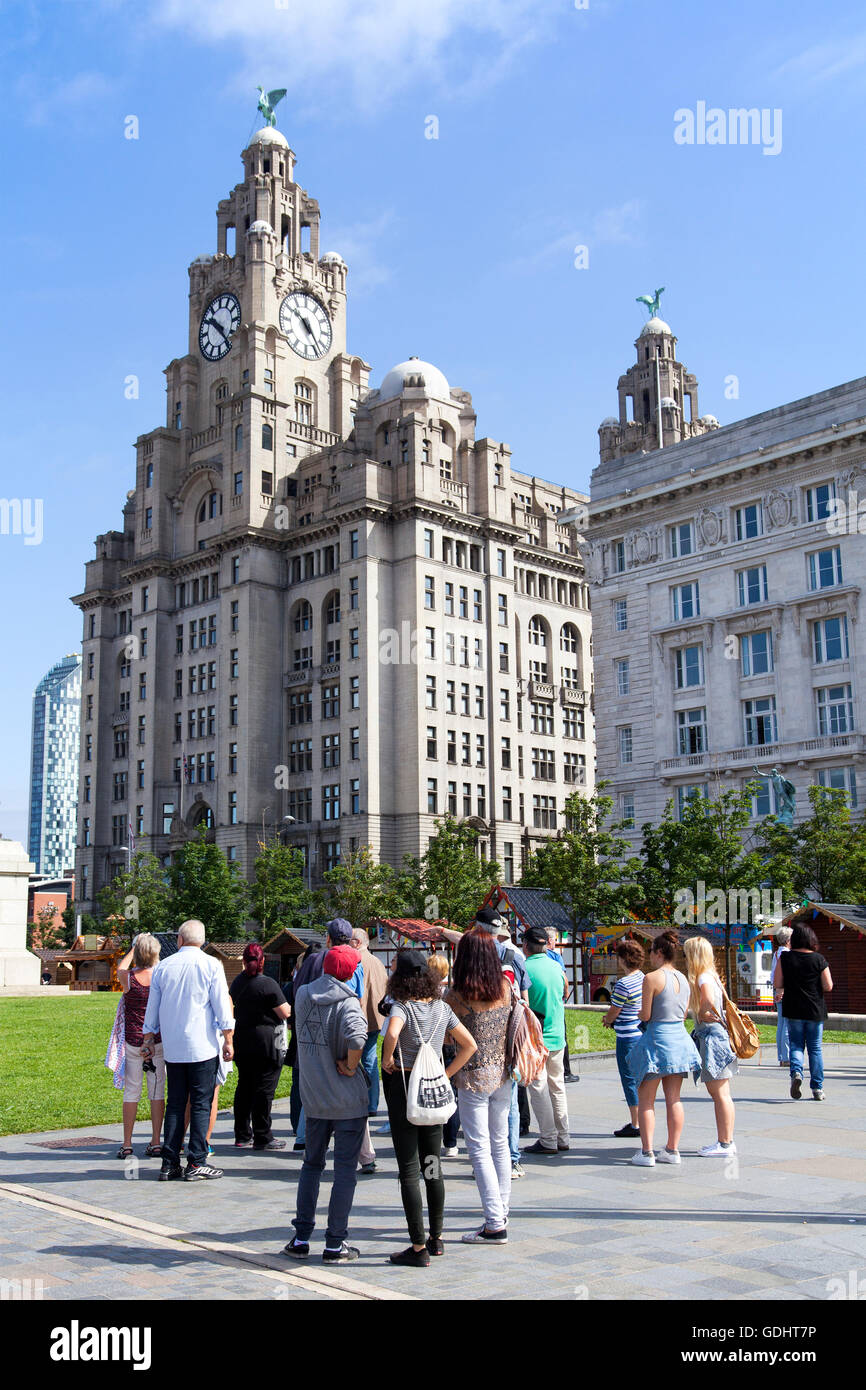 Liverpool, Merseyside Regno Unito.18 Luglio, 2016. Regno Unito Meteo. Una calda giornata di sole su Liverpool accoglie gli studenti stranieri e turisti provenienti dall'UE. Le visite guidate prendere loro lungo il percorso della città famosa storia con gite a 'Beatles Story' e fab four sculture. Contro il magnifico sfondo di 'le Tre Grazie' compresa la famosa "Liver Building', i visitatori sono assegnati a una guida per mostrare loro le attrazioni storiche della città ha da offrire. Credito: Cernan Elias/Alamy Live News Foto Stock