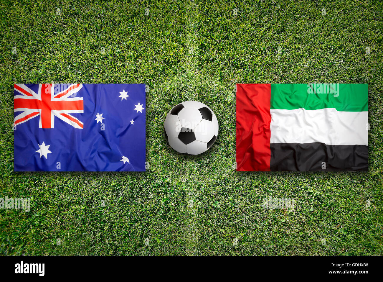 Australia vs Emirati Arabi Uniti bandiere sul verde del campo di calcio Foto Stock