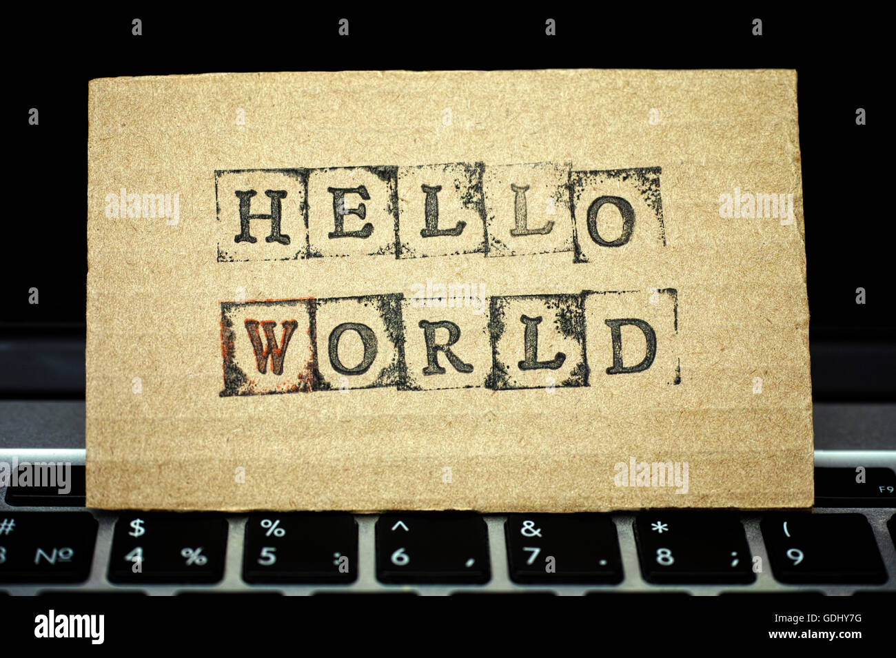 Cartone con parole Ciao mondo fatto da nero timbri alfabeto permanente sulla tastiera del notebook. Foto Stock