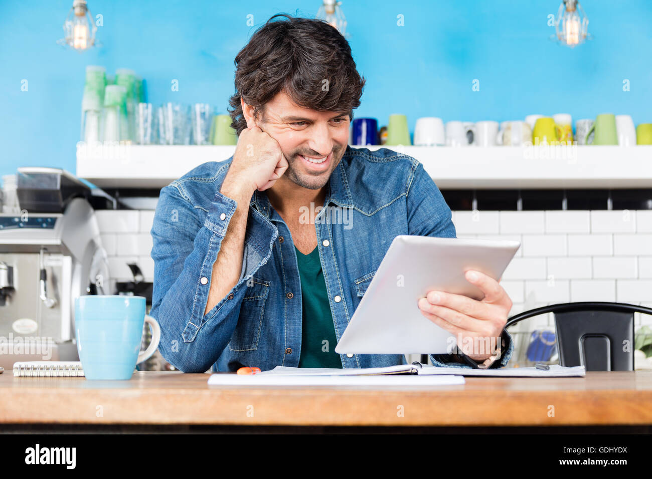 Uomo che utilizza computer tablet imprenditore casual sorriso seduta Foto Stock