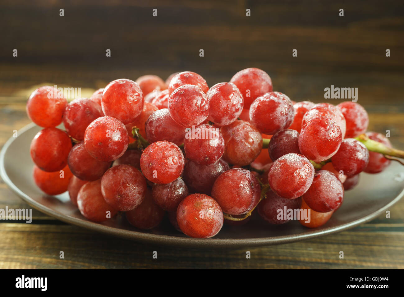 Grappolo di uva rossa su sfondo scuro Foto Stock