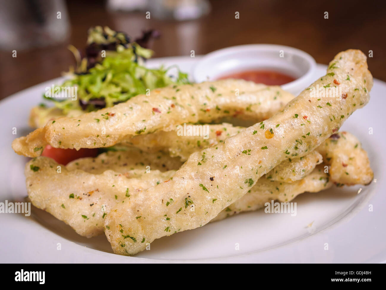 Tempura di pollo servito con foglie di insalata e salsa chili Foto Stock
