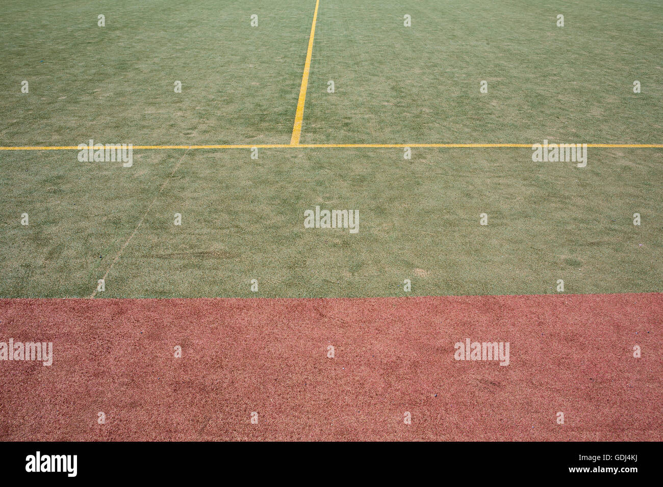 Astro turf pitch coperto di sabbia con linea gialla e rossa e verde sezioni. Foto Stock