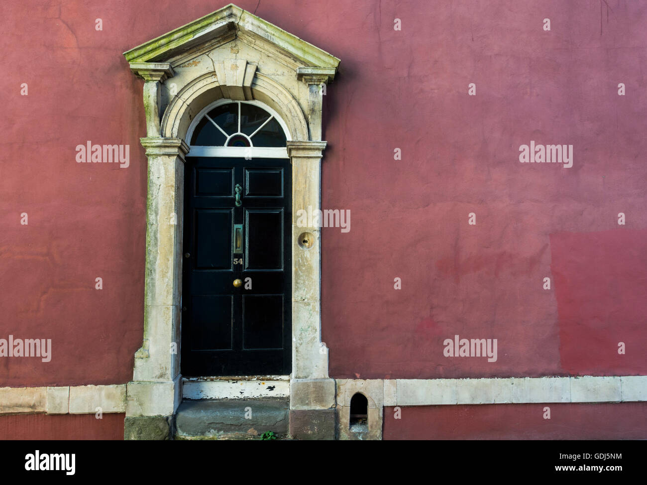 Porta nera con una rosa scuro muro, architettura georgiana del Kingsdown area di Bristol, Regno Unito Foto Stock
