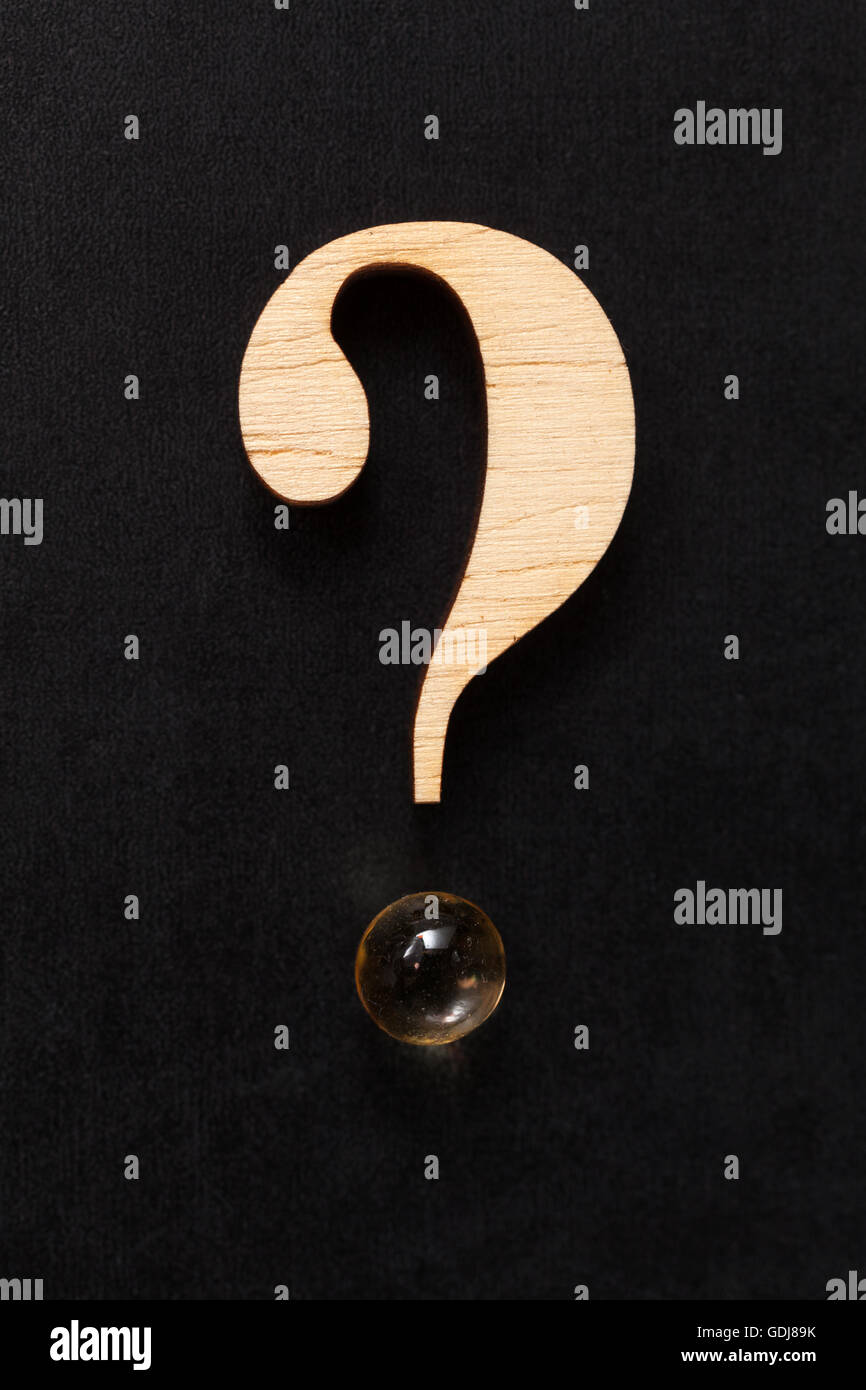 Punto interrogativo formata di legno e una pillola Foto Stock