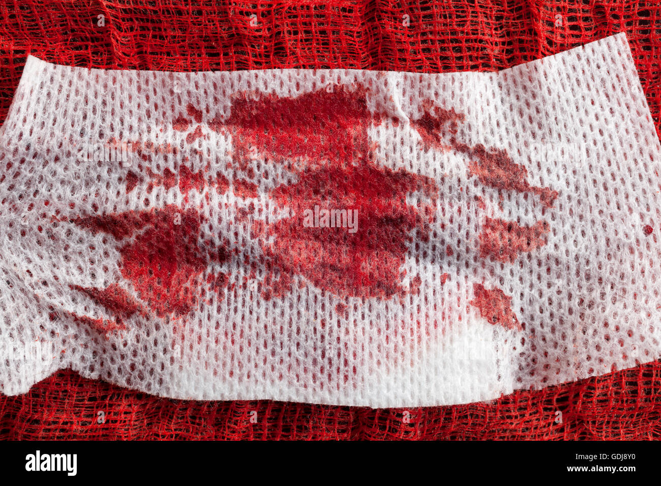 Tessuti a punto di garza con il sangue su sfondo nero Foto Stock