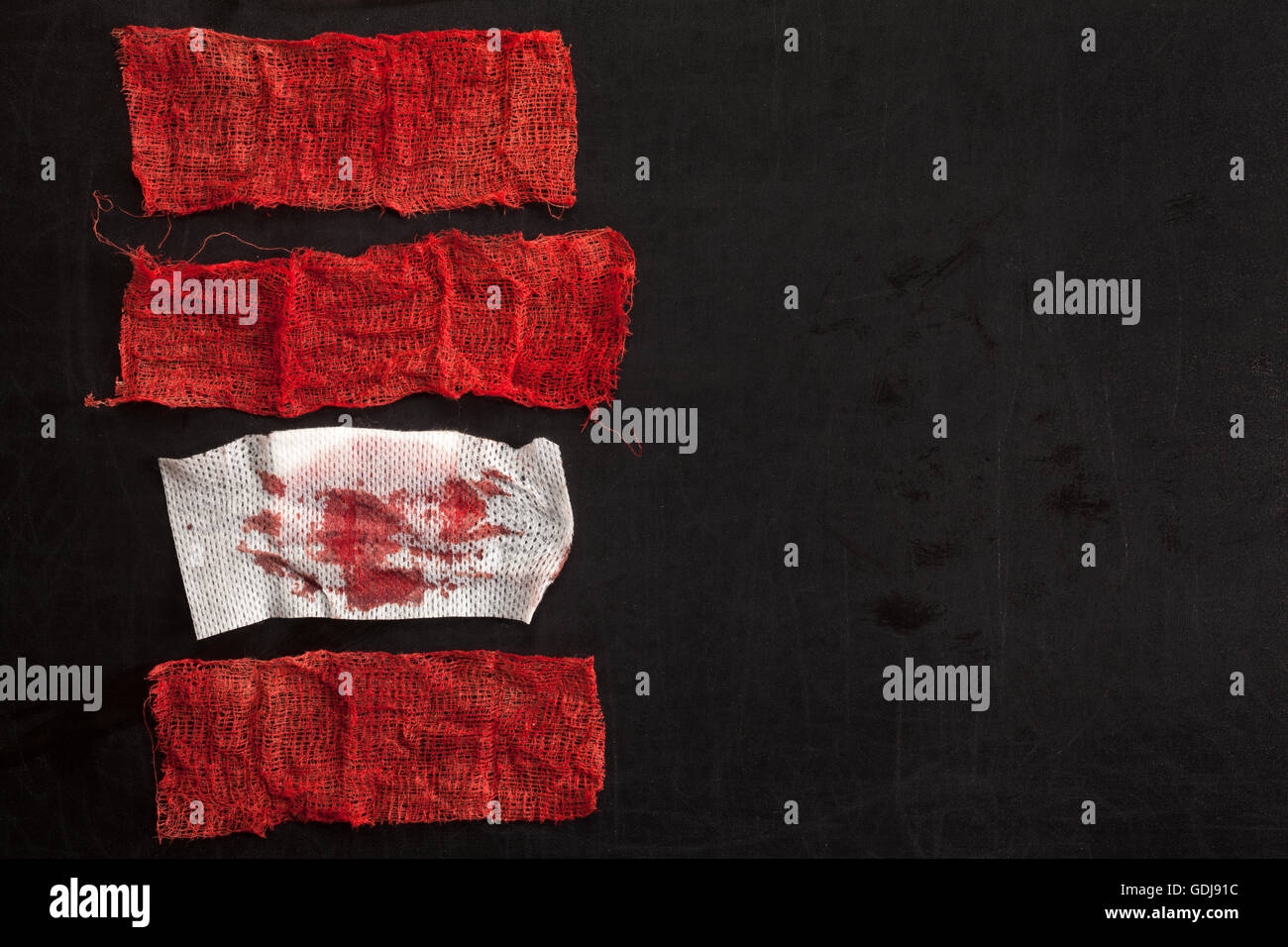 Tessuti a punto di garza con il sangue su sfondo nero Foto Stock