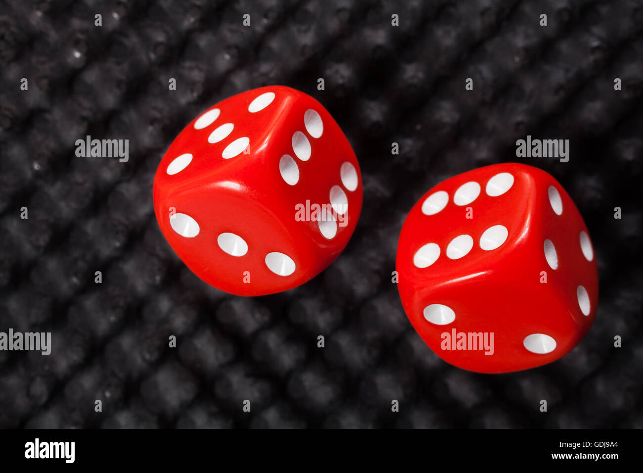 Dadi rossi su sfondo nero Foto Stock