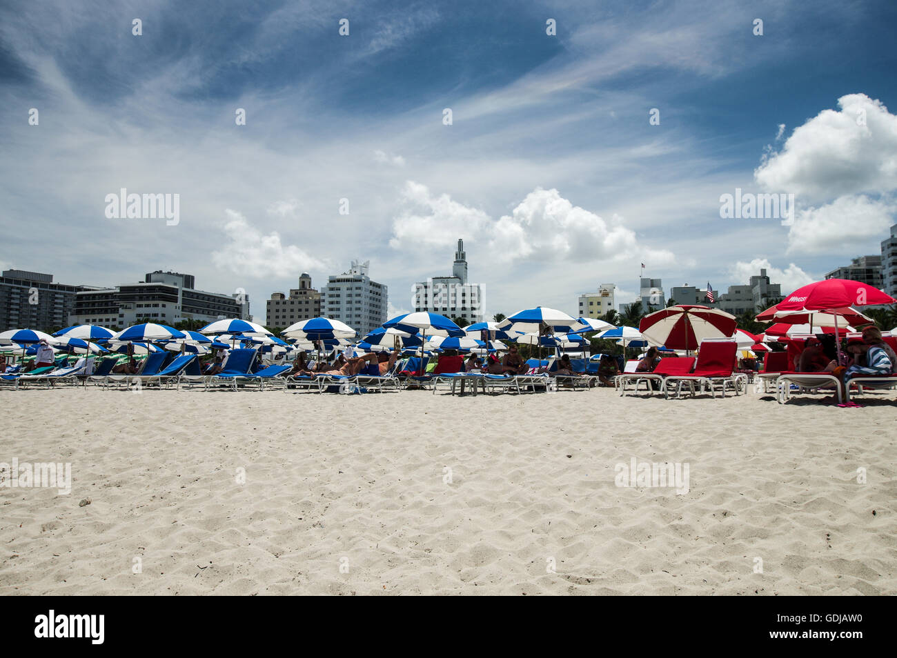 Blu e rosso ombrelloni con Delano e National Hotel in background sulla spiaggia di South Beach a Miami Foto Stock