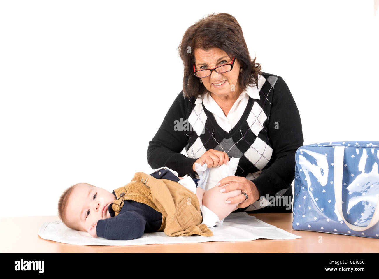 Nonna cambiando pannolino per bambino isolato in bianco Foto Stock