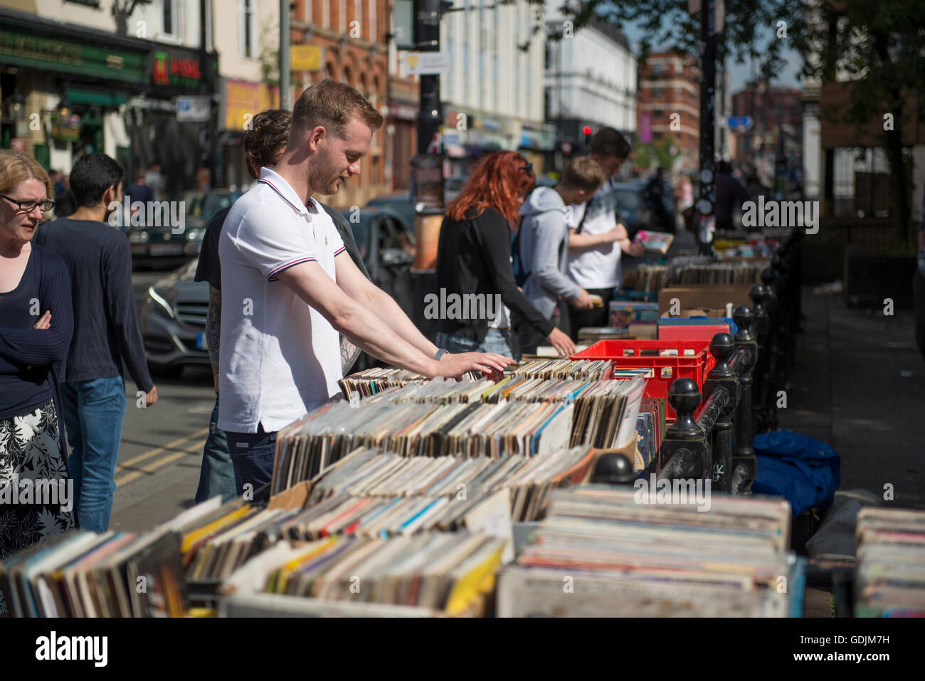 Un giovane uomo setaccia attraverso 2a mano i record per la vendita in una fase di stallo su Thomas Street nel quartiere settentrionale area di Manchester. Foto Stock
